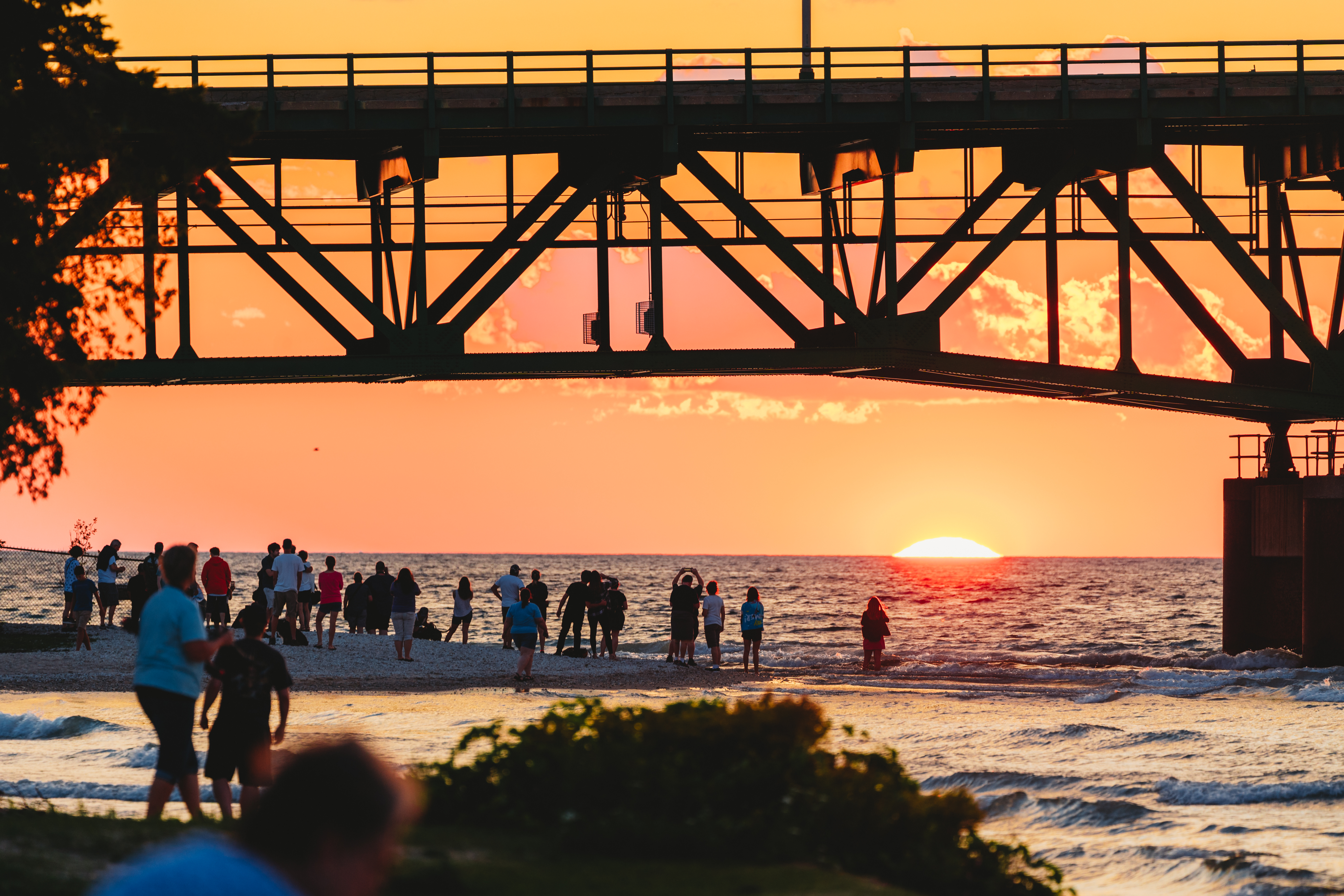 Mackinac Bridge A group of people gathered by the Mackinac Bridge on the shore.