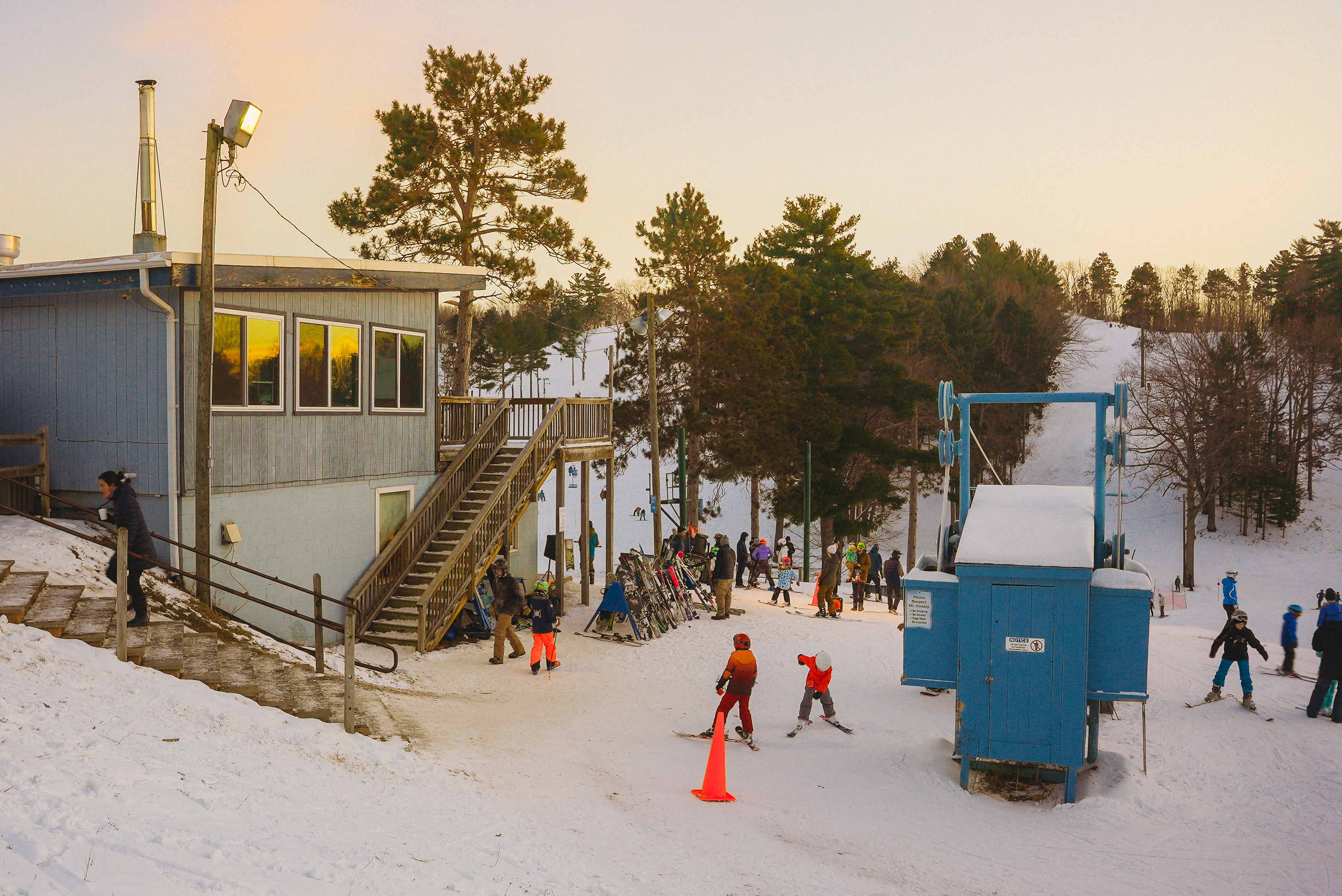 Skiiers and snowboarders walking at the base of a ski hill at Mt. Holiday