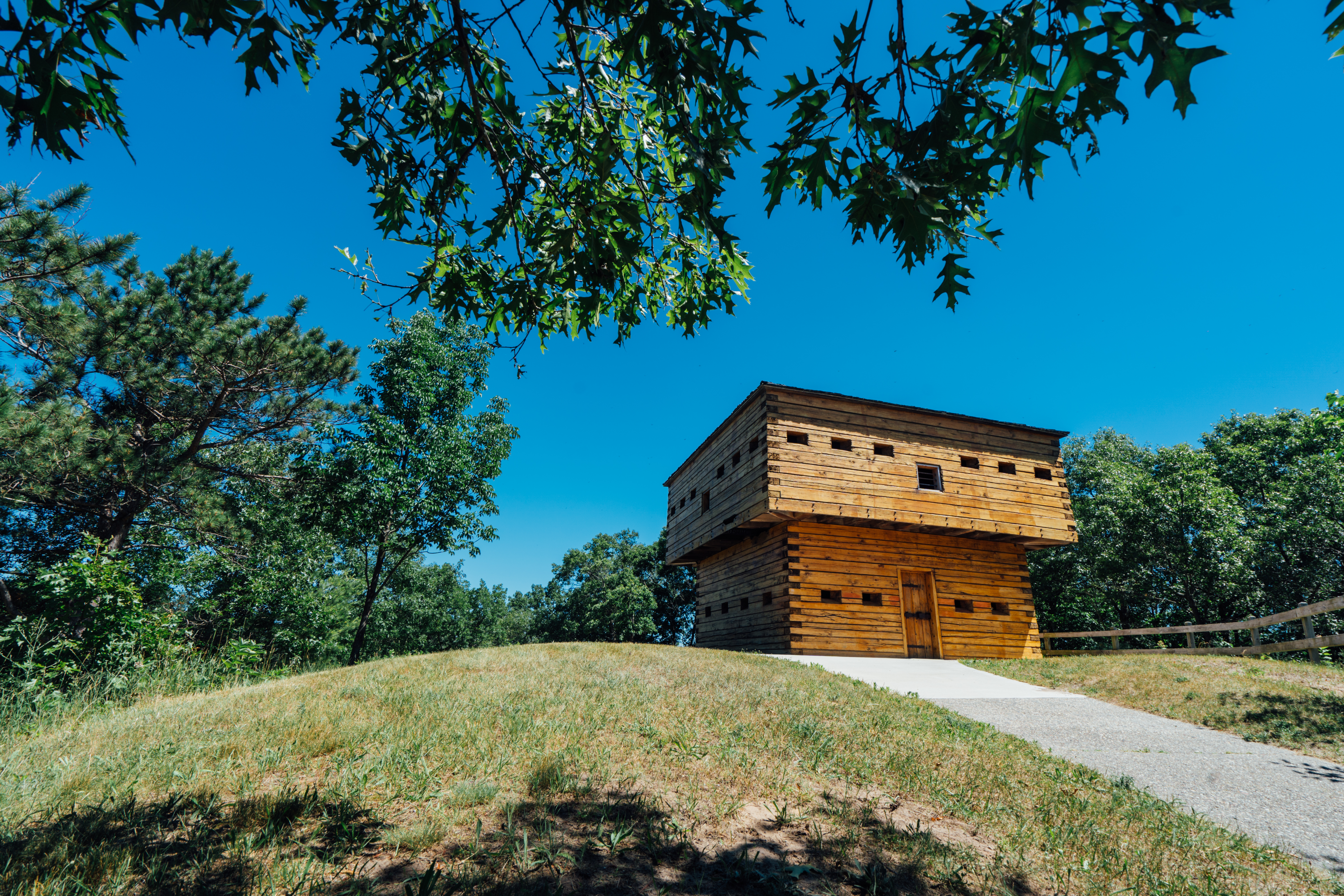 A historic log building by a walking path.