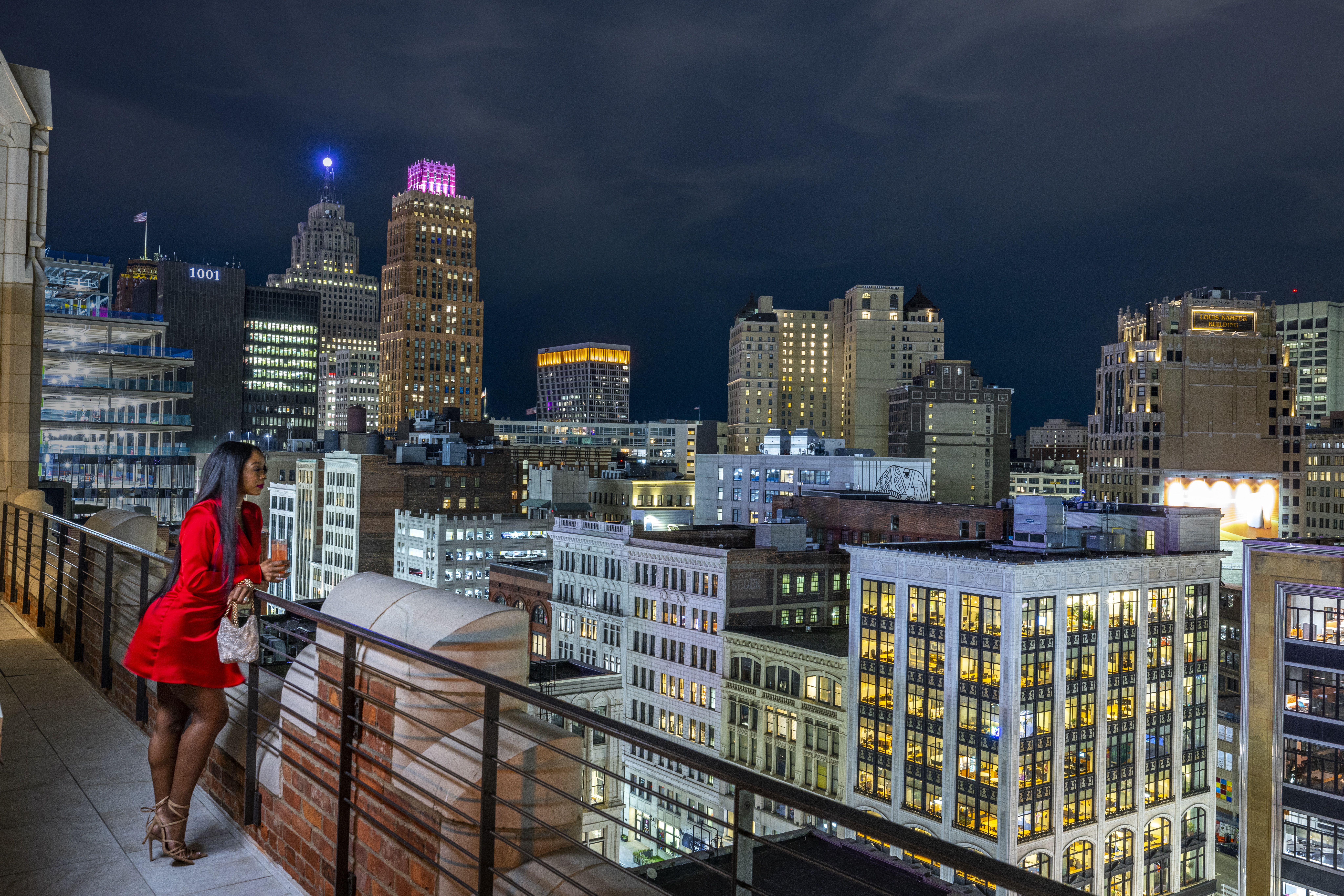 A woman standing on a balcony in downtown Detroit
