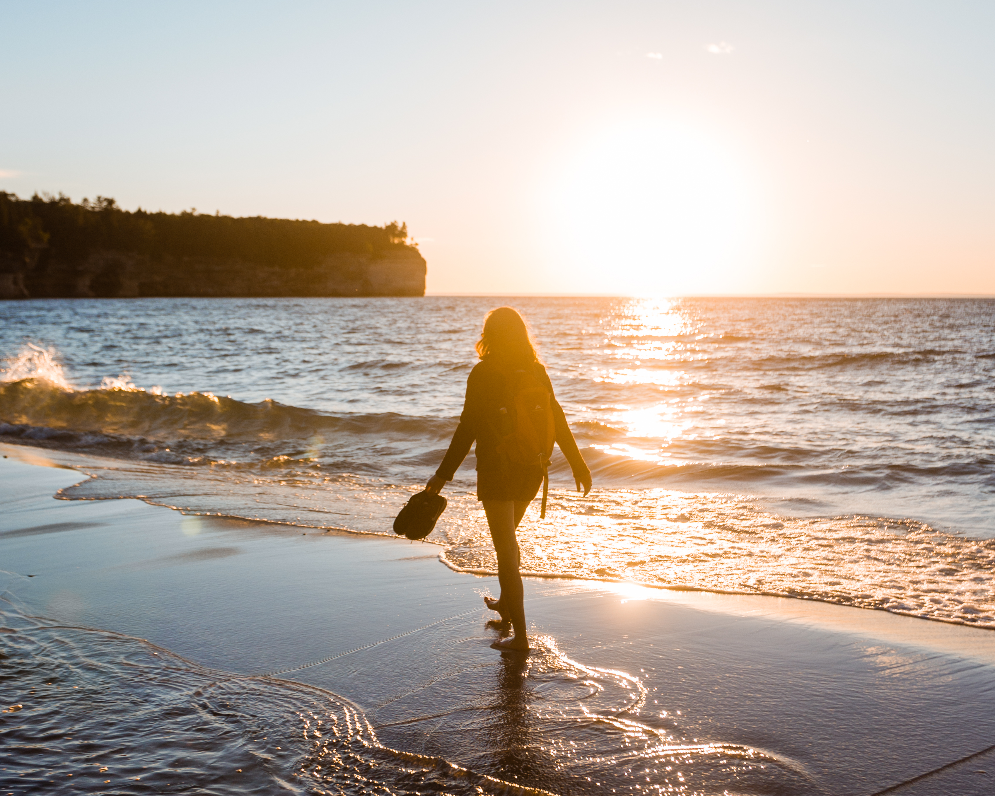 Pictured Rocks National Lakeshore A woman walking on a beach along Lake Superior