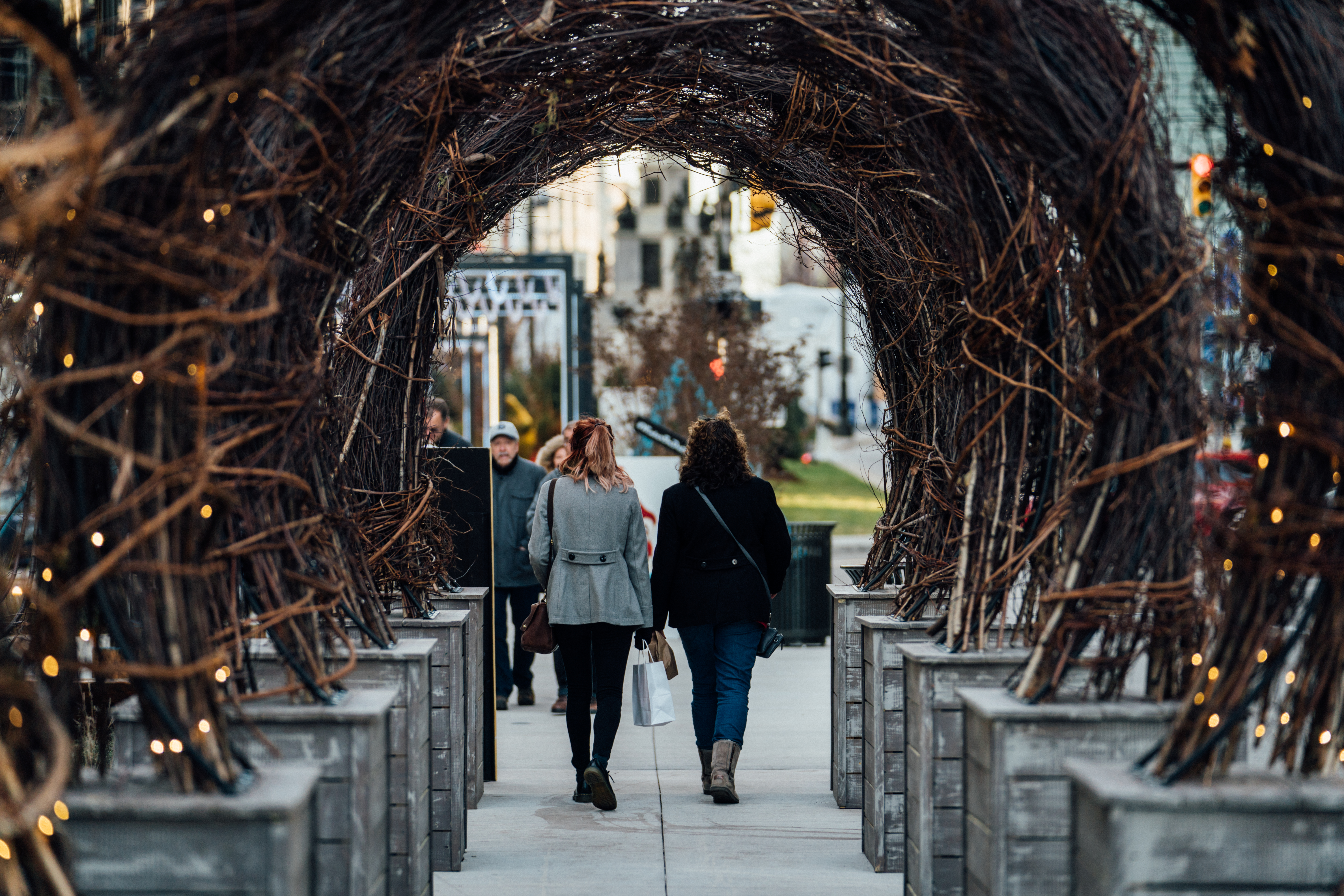 Two woman walking under wood arches in downtown Detroit