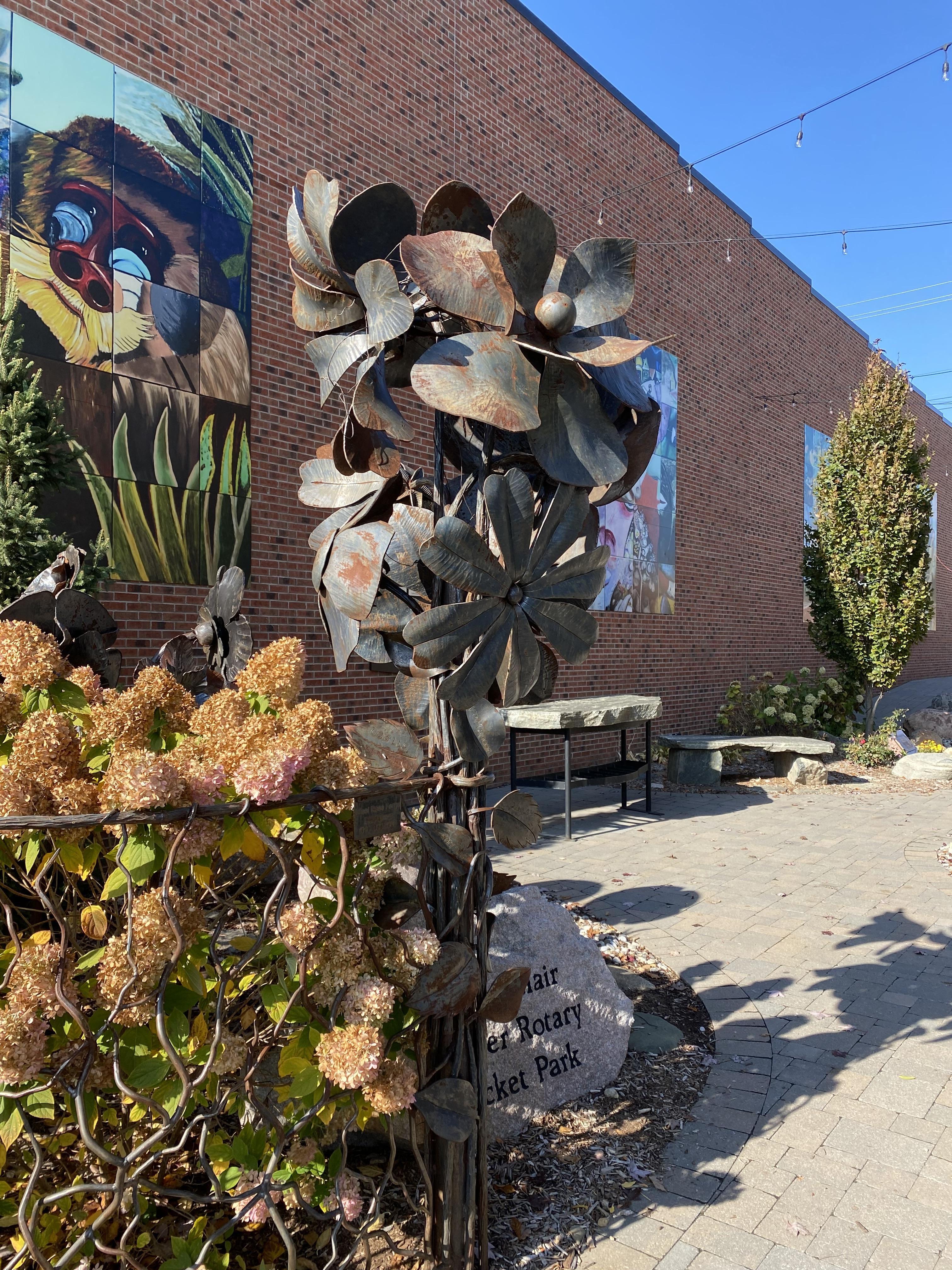 Ed LaClair Lapeer Rotary Park A metal sculpture of flowers in a garden park
