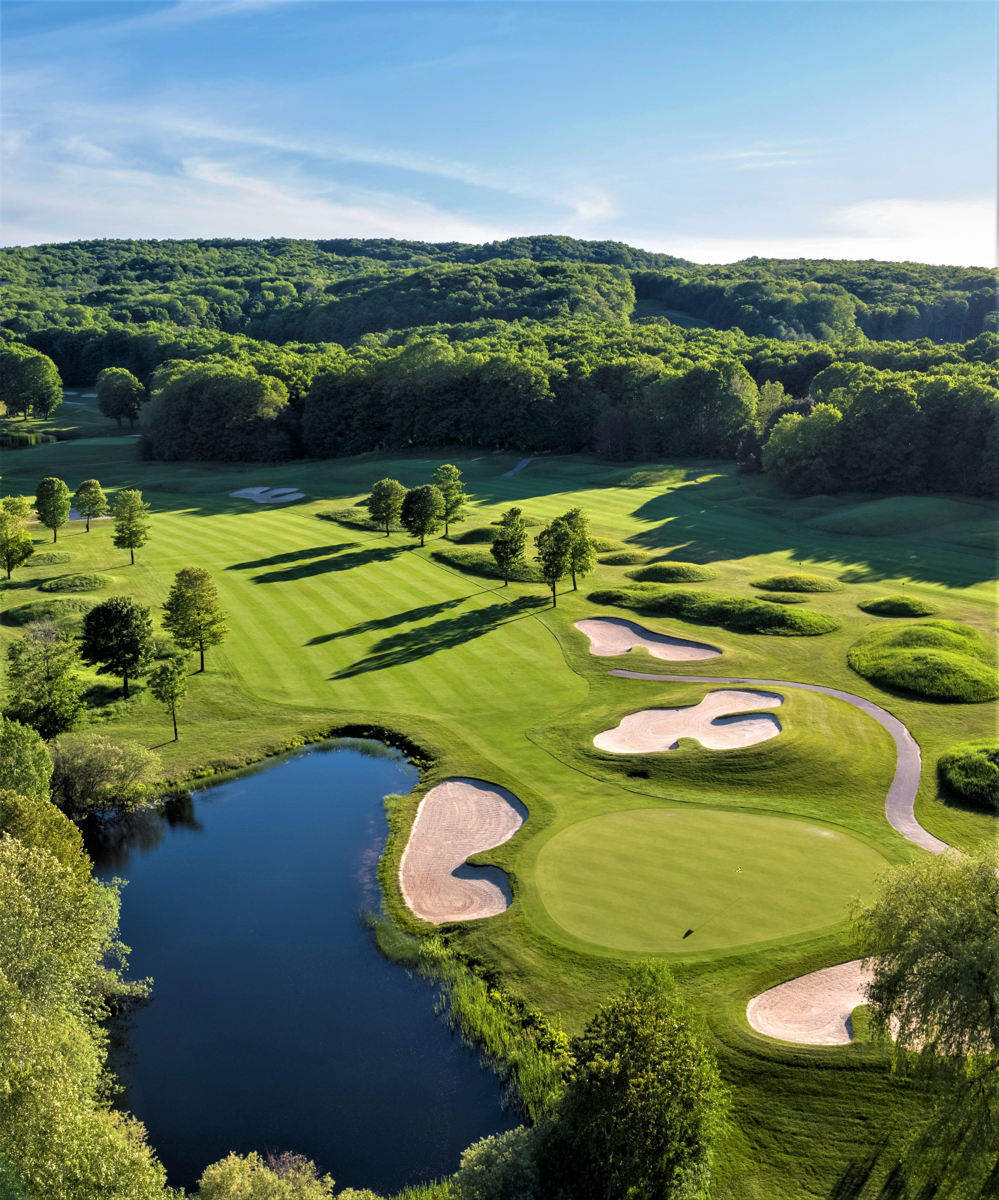 A golf course with a water feature and sand traps. 