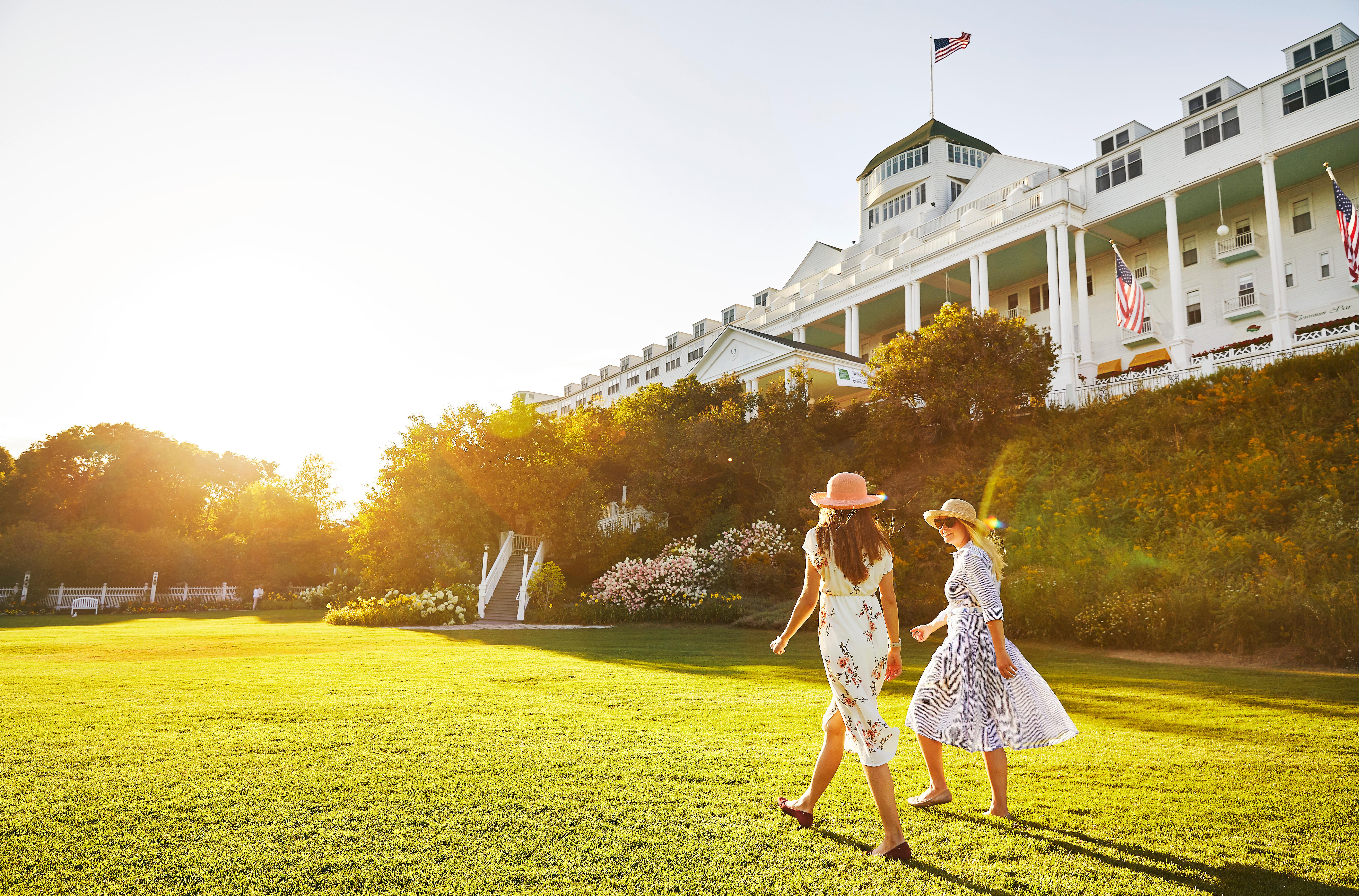 Two woman walking in a lawn in front of the Grand Hotel