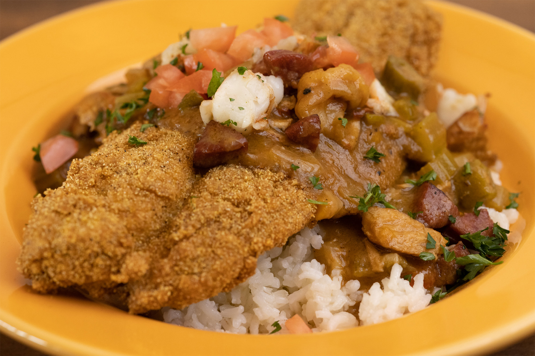 Fried fish over a bed of rice and vegetables