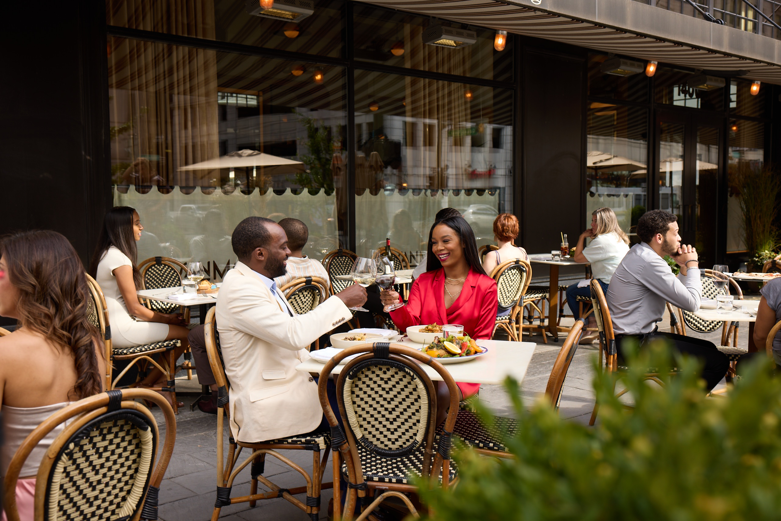 A couple toasting with wine glasses on an outdoor patio