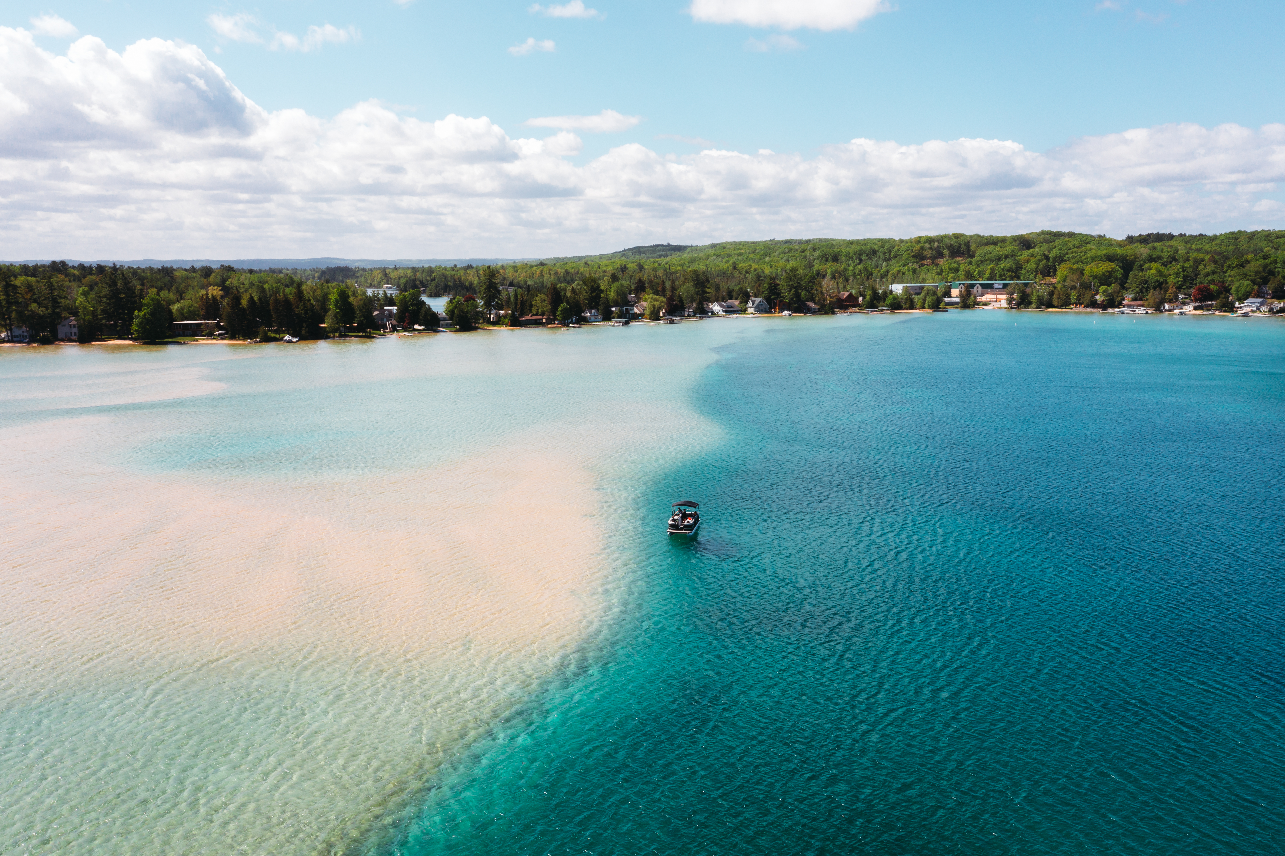 Torch Lake A boat floating on a large inland lake.