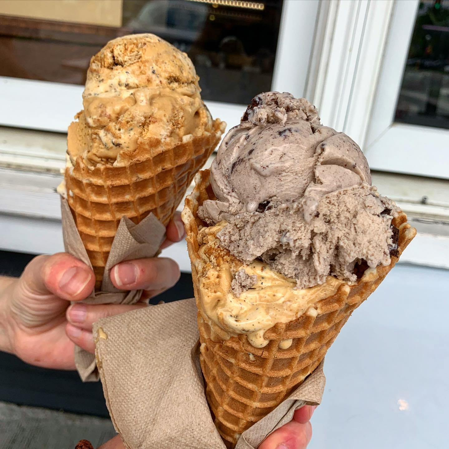 Blank Slate Creamery Two people holding ice cream cones together.