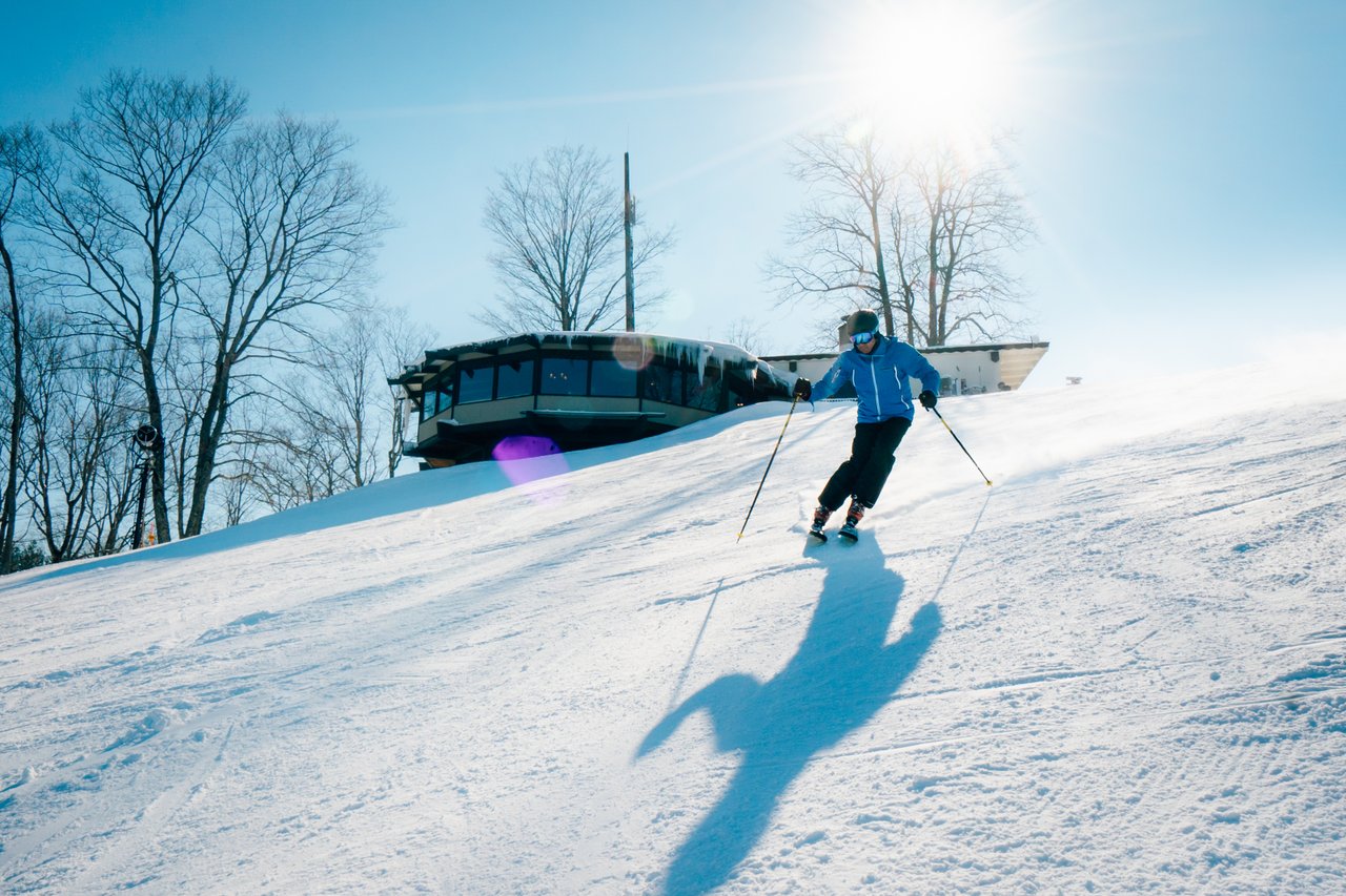 Boyne Mountain Resort | Photo Courtesy of Pure Michigan skier coming down the hill on a sunny day