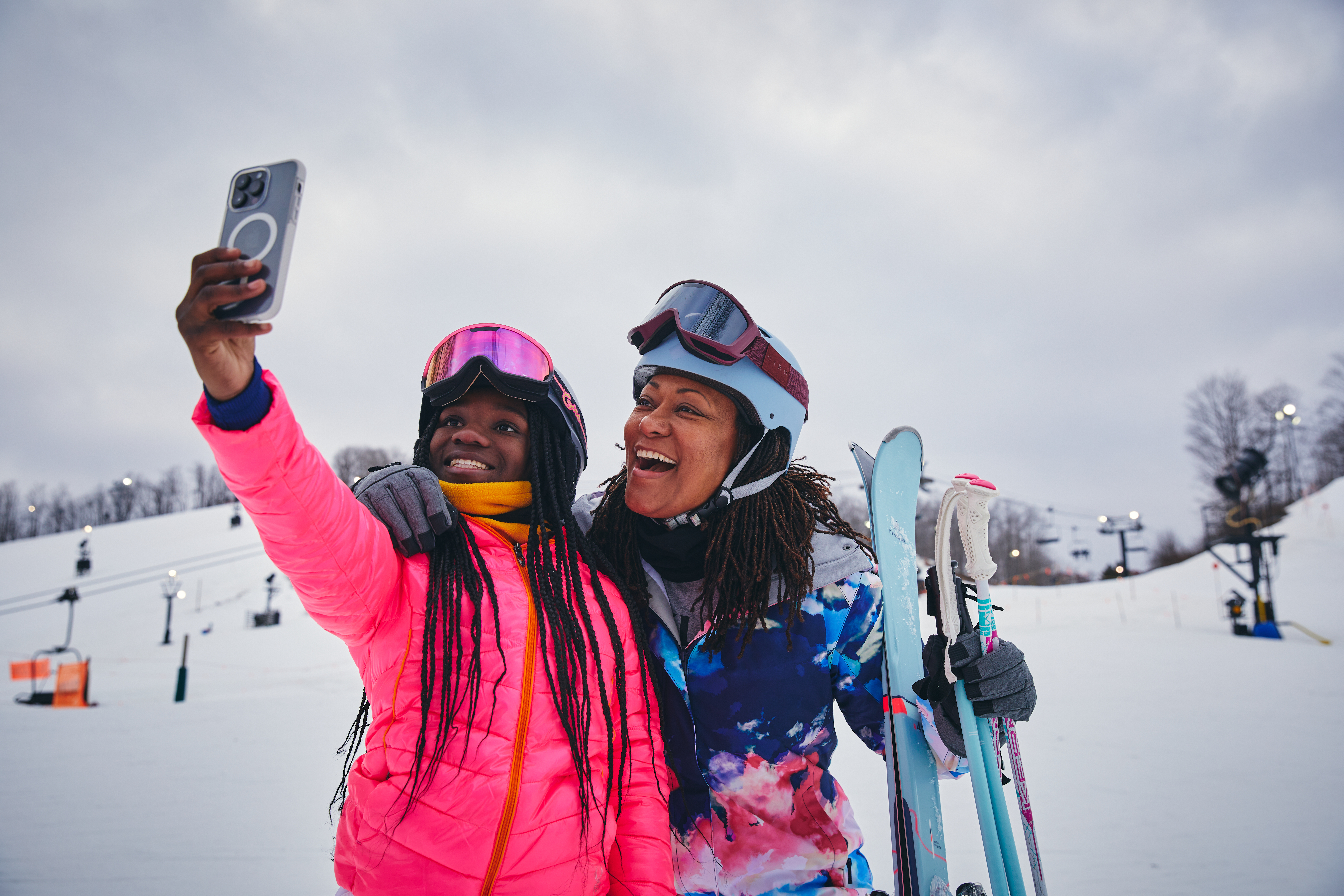 Skiing at Crystal Mountain 2 skiers taking a selfie slopeside