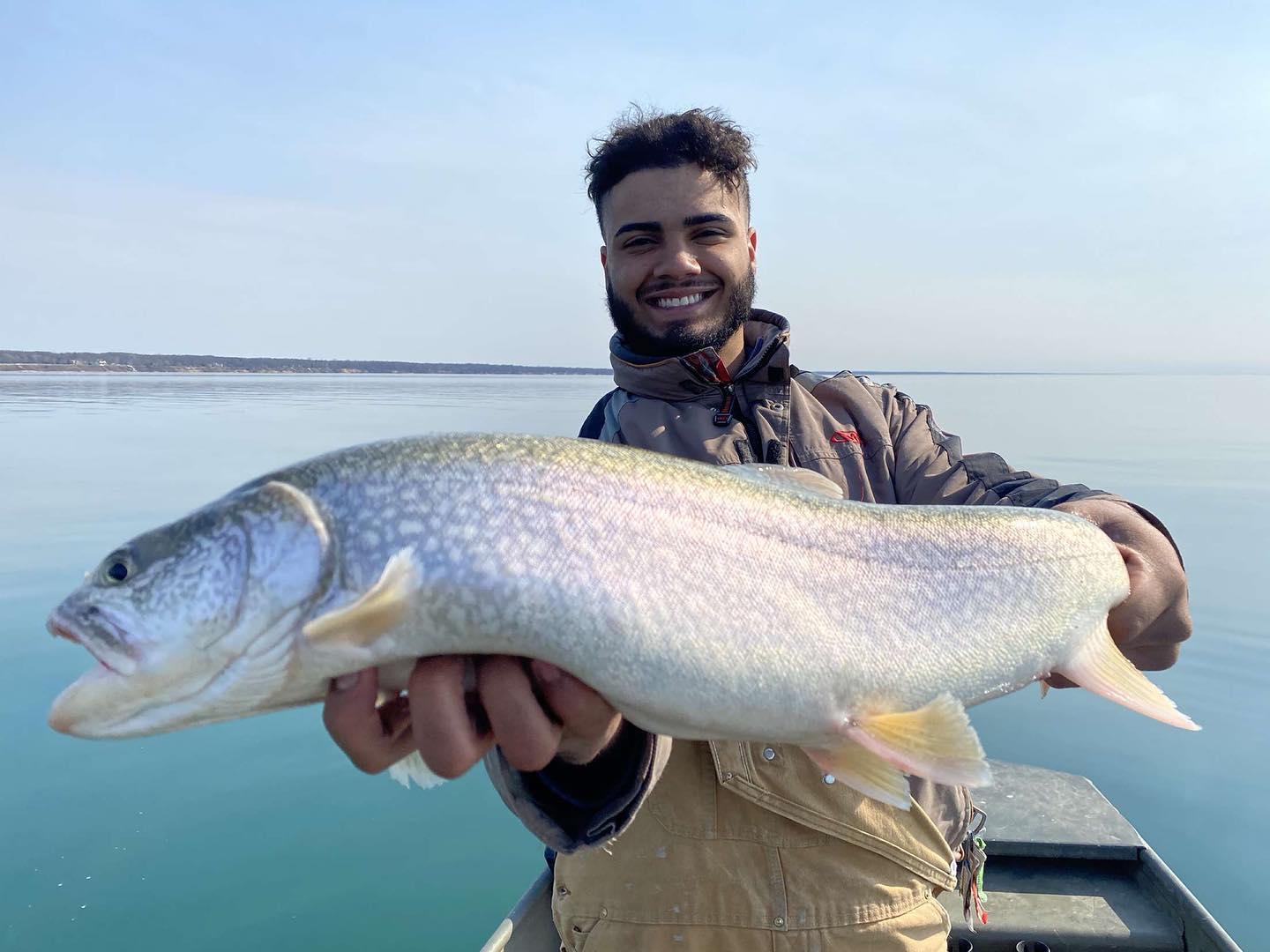 Trout fishing in Michigan A man holding a trout in a boat