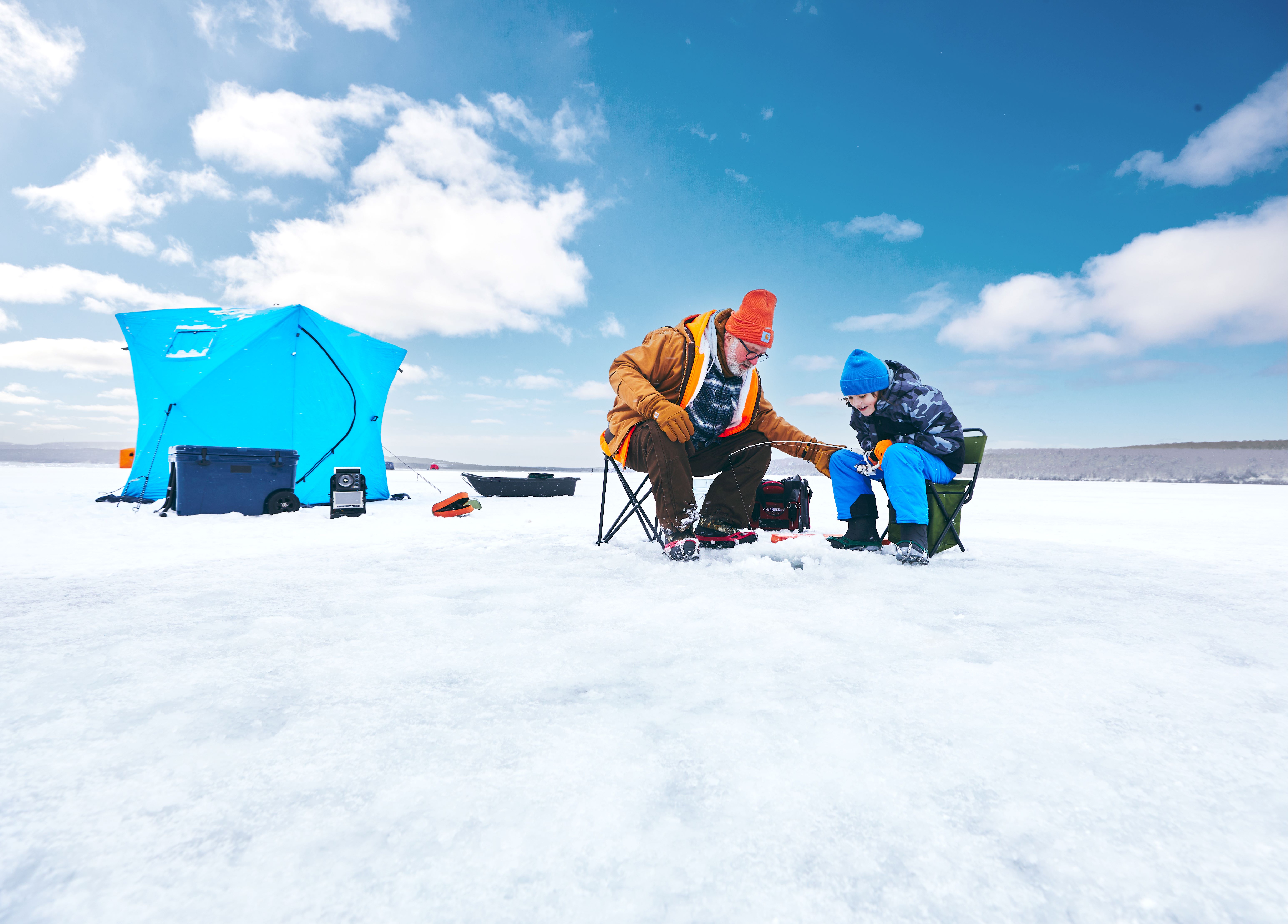 Ice Fishing in Munising A man and boy ice fishing on a frozen lake.