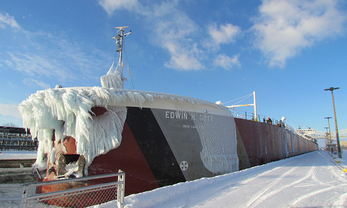 freighter at dock covered in snowy ice dripping off the front