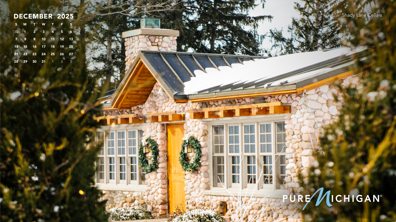 2025 Pure Michigan Calendar - December A December 2025 calendar graphic on a photo of the exterior of a winery during winter.