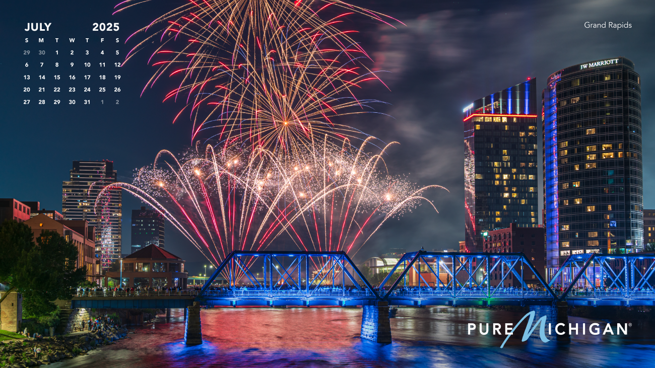 2025 Pure Michigan Calendar 2025 - July A July calendar graphic on an image of fireworks over the Grand River in Grand Rapids.