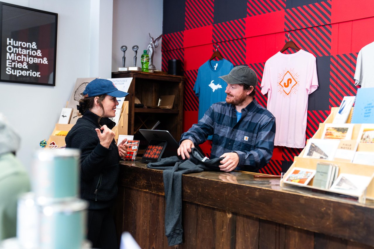A woman purchasing a t-shirt in a store. 