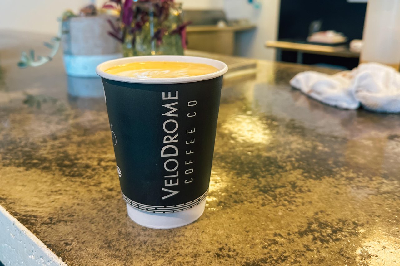 A latte in a to-go coffee cup on a countertop. 
