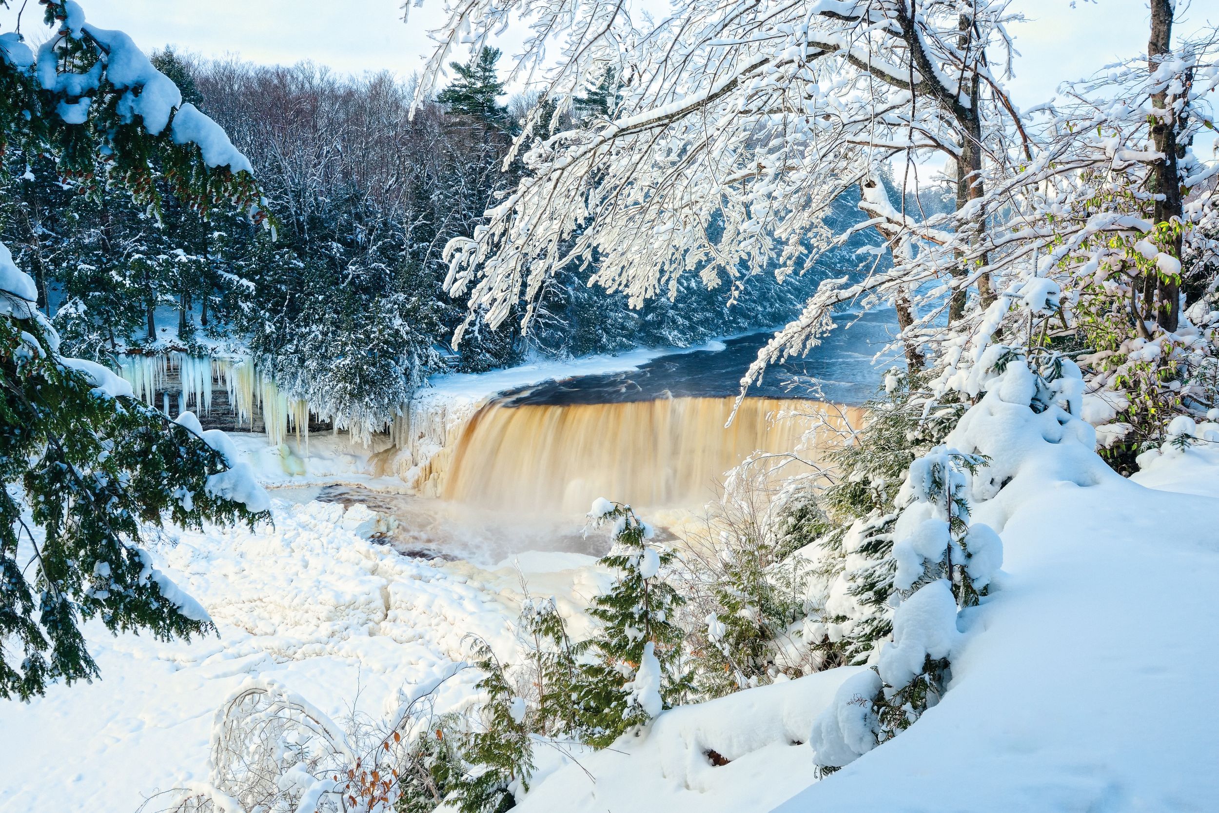 Tahquamanon Falls surrounded by snow and ice during winter.
