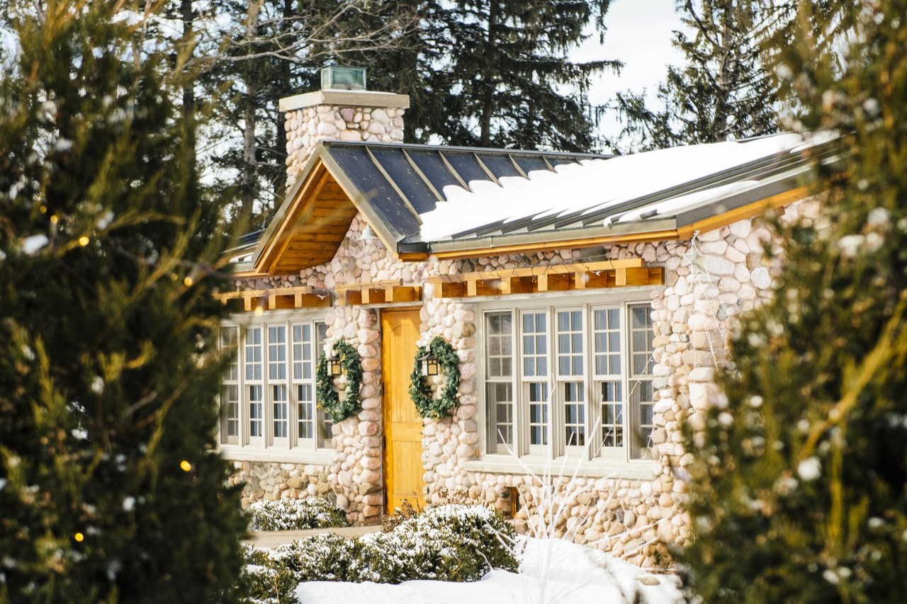 Exterior of Shady Lane Cellars surrounded by evergreens covered in snow. 