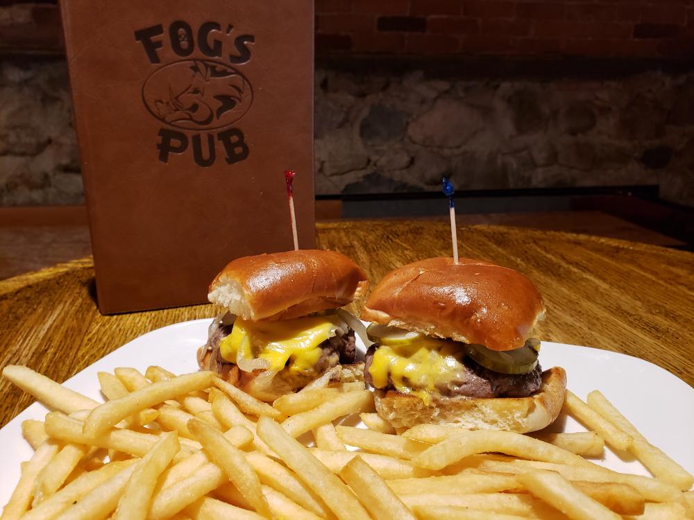A plate with two cheeseburgers and french fries.  