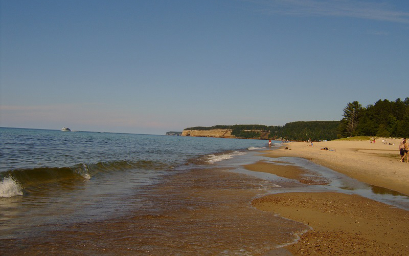 sandy beach by the lake sky is blue and hazy