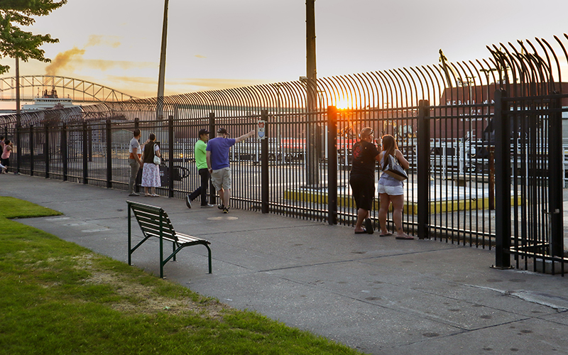 people watching the ships from the sidewalk