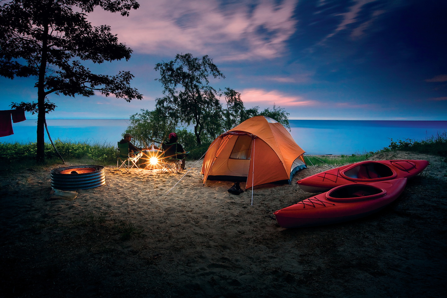 Camping in Michigan Man and woman at campsite beside lake
