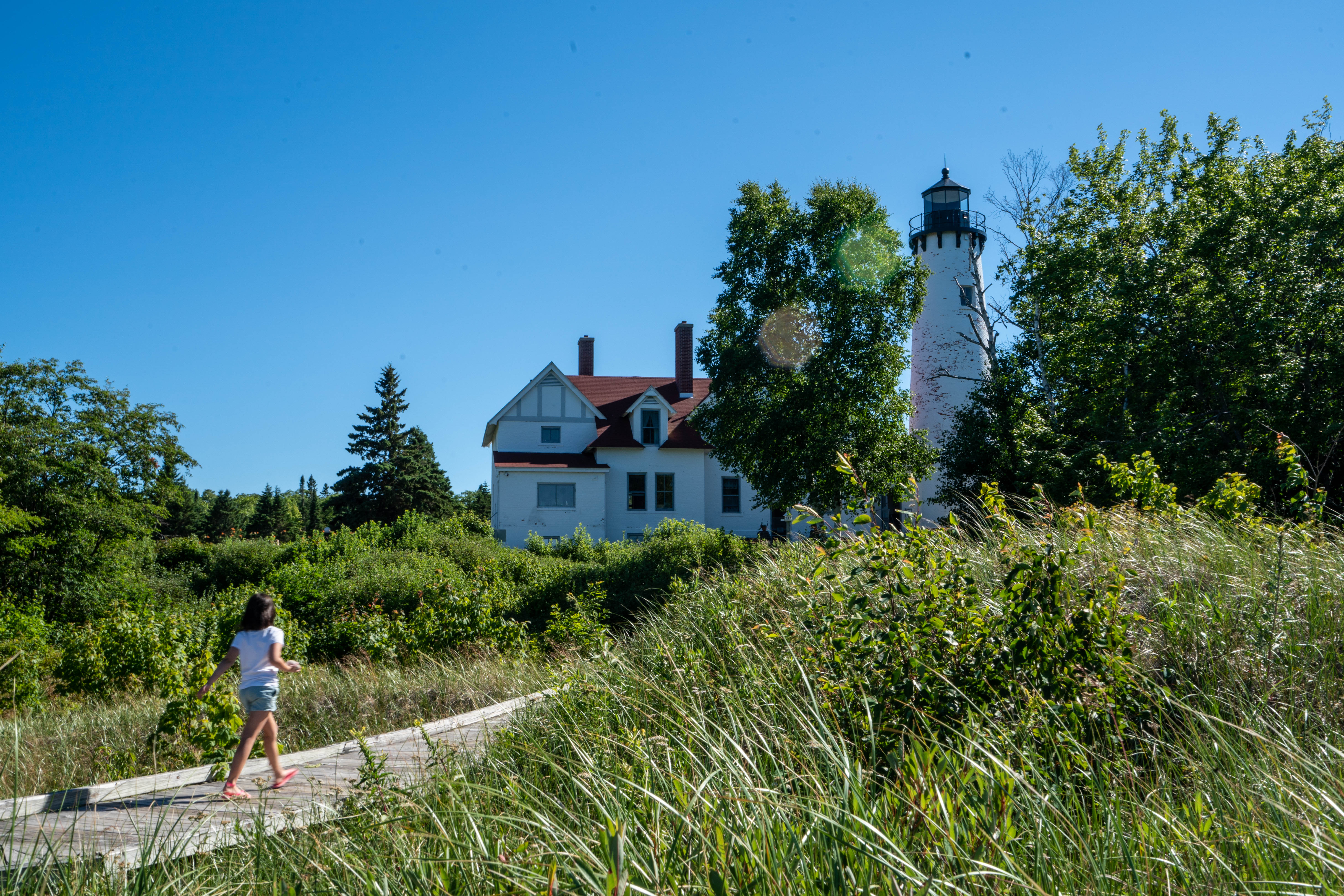 Girl walking by Point Iroquois Lighthouse