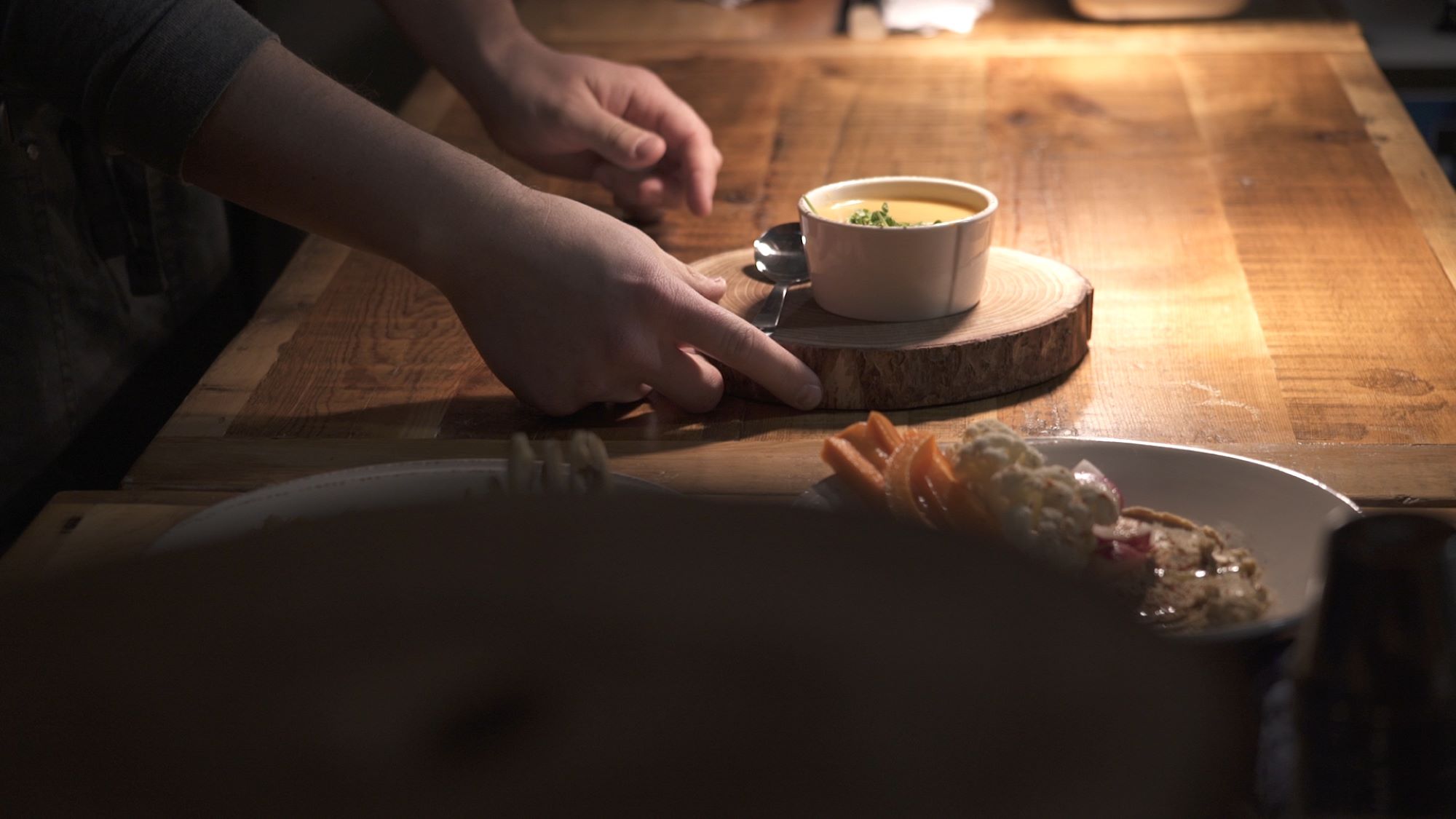 A bowl of soup on a wooden plate