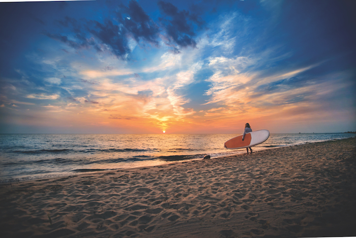 Paddle boarder walking into Lake Michigan in Grand Haven