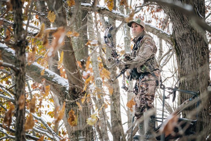 Molly Rinckey with hunting bow in snowy forest