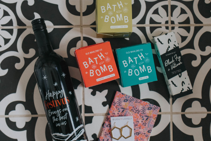A bottle of wine, bath bombs, and earrings.