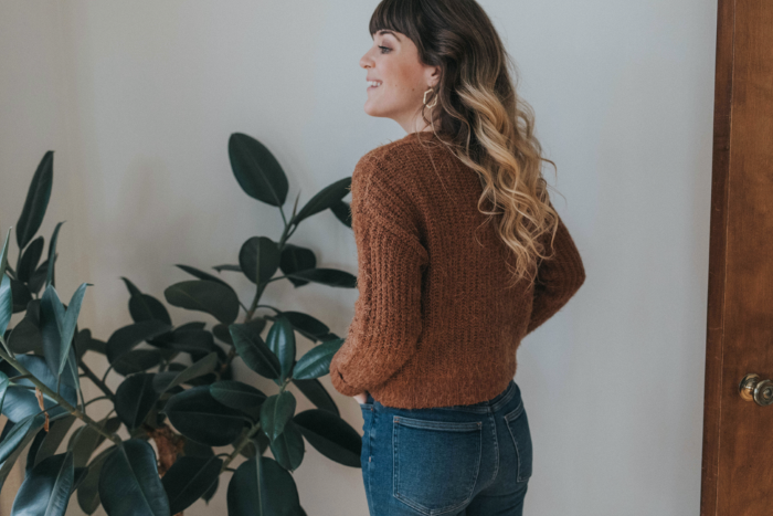 Woman in sweater and earrings.