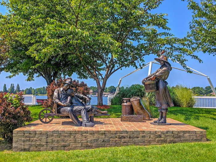 A sculpture of a farming family with produce around them.