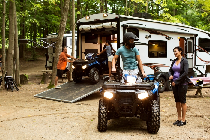a group getting their off road vehicles ready to ride at a campsite.