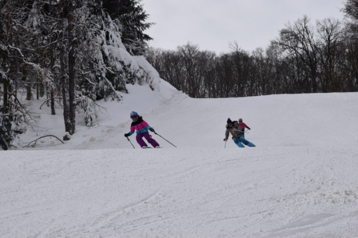 A group skiing down a hill at Ski Brule.
