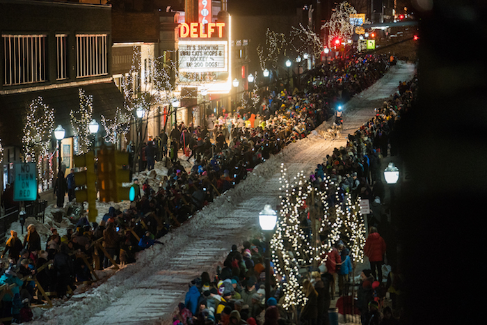 Crowds line the streets of Downtown Marquette as a dog sled team races by