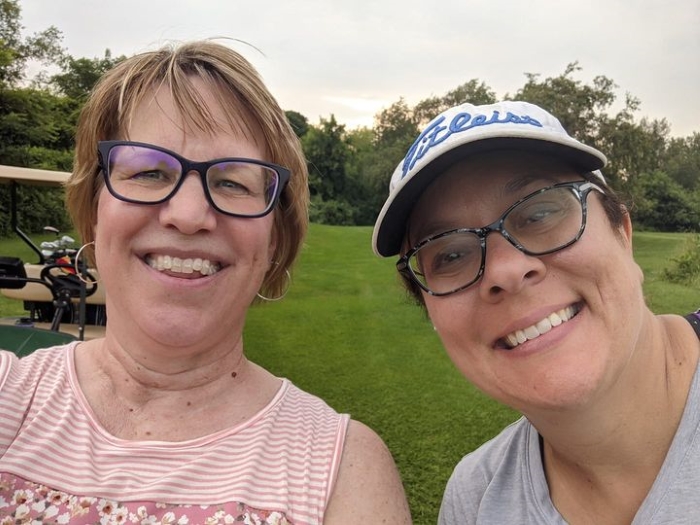 Author Jada Paisley with a woman on a golf course.