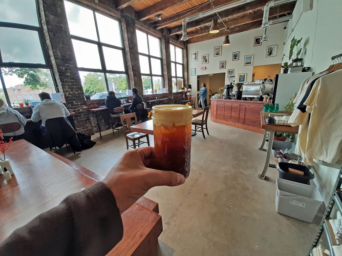 Aaron Cruz holding coffee at the Gathering Coffee Co.