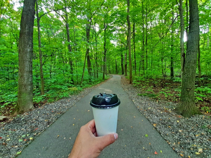 Aaron Cruz holding coffee on trail at Mayberry State Park