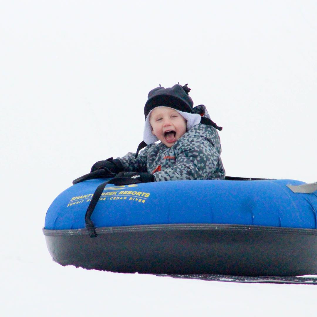 Child laughing in snow tube