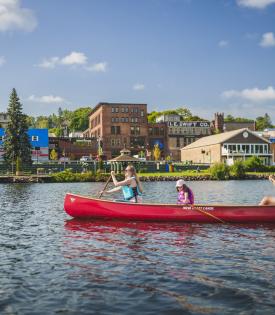 family canoeing in front of the waterfront on a sunny day in the keweenaw peninsula