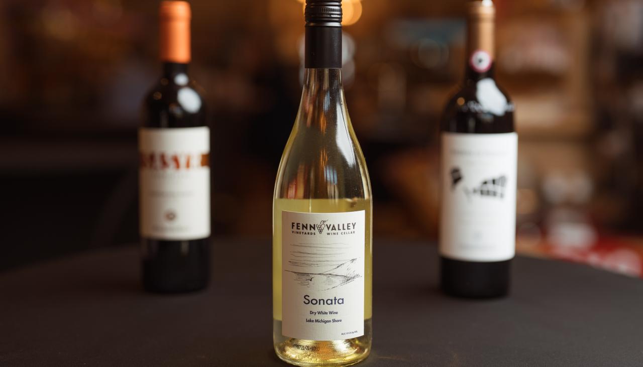 Three bottles of Michigan-made wine on a table