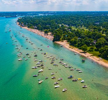 coastline and lake huron with many boats parked in the blue/aqua/green water