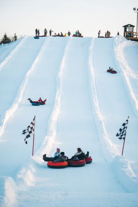 Menschen fahren Snowtubes auf verschneiten Hügel