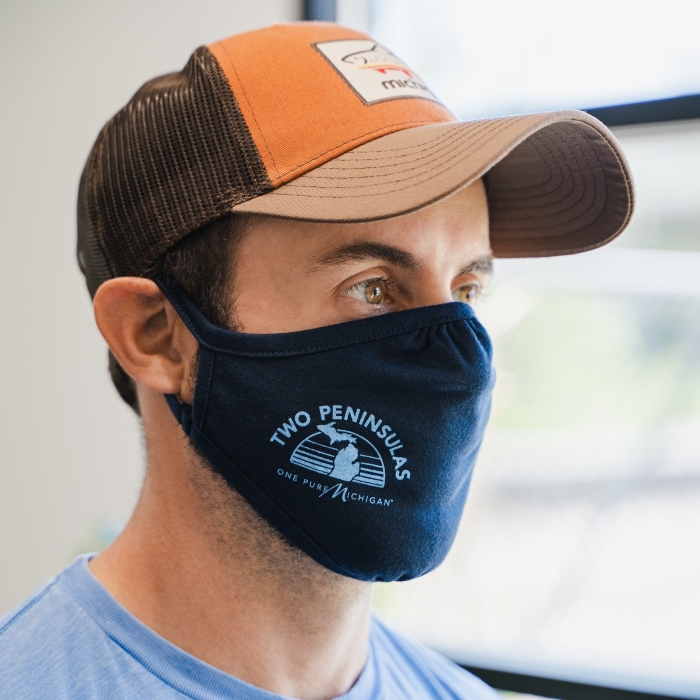 Adult man wearing a cloth facemask with a graphic design