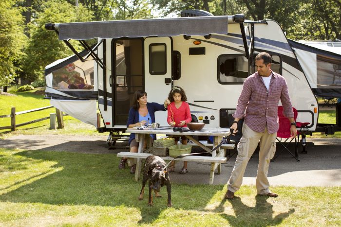 Family sitting by Expandable Travel Trailer