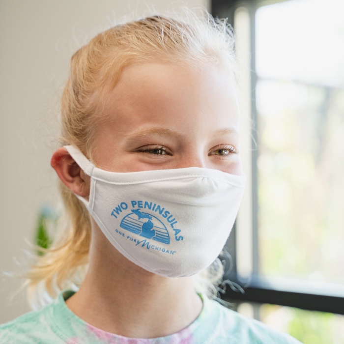Young girl wearing a cloth facemask with a graphic design