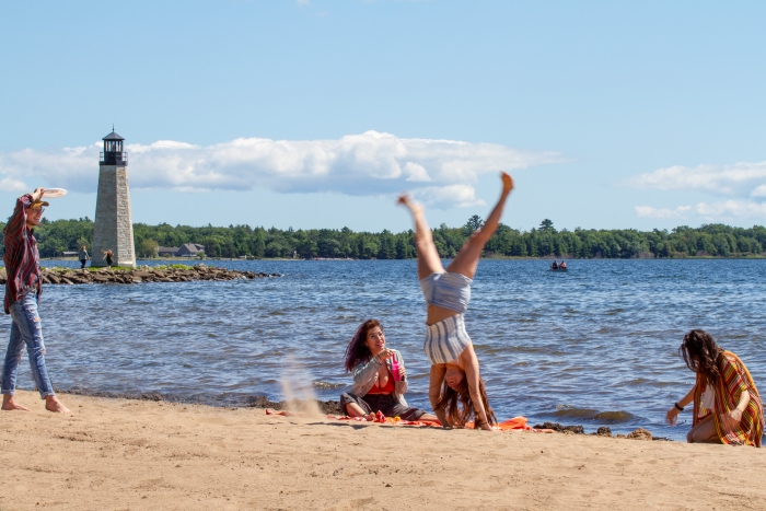 A girl doing a cartwheel on a beach in Escanaba